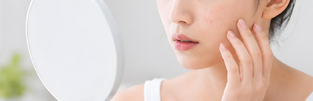 鏡を見ながら頬の肌を気にする女性