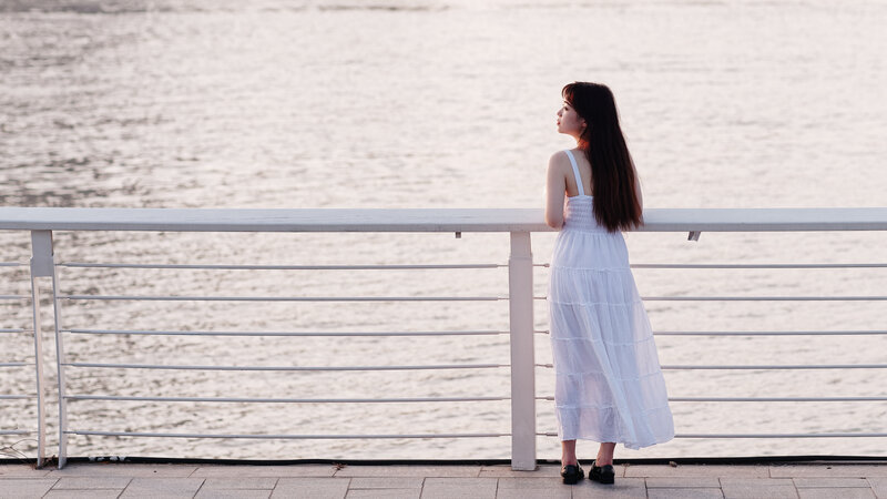 海を眺める白いワンピースの女性の横顔ショット