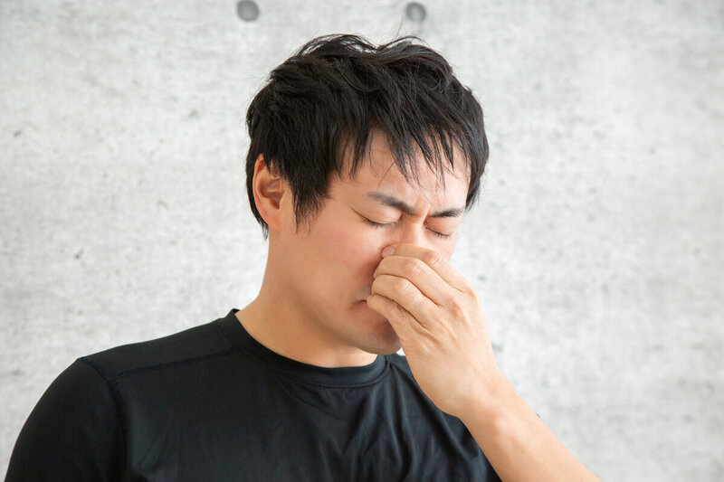 鼻に手を当てて考えている男性の横顔